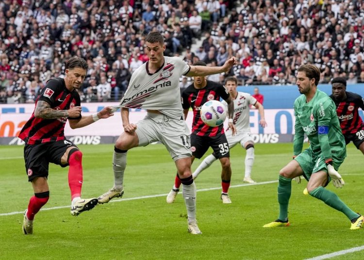 Frankfurt's Robin Koch, Leverkusen's Patrik Schick and Frankfurt's goalkeeper Kevin Trapp, from left, challenge for the ball during their German Bundesliga match.