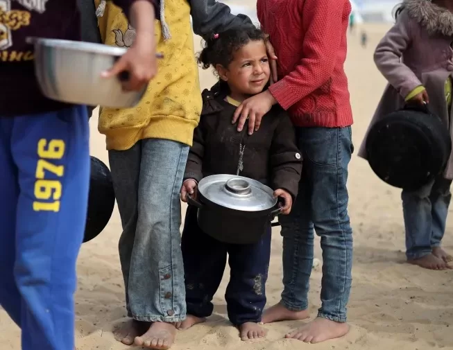 UN: Israel closure of Gaza crossings 'completely crippling' aid 1 - Egyptian Gazette Displaced Palestinian children wait to receive food at a tent camp in Rafah in the southern Gaza Strip, February 27, 2024. Reuters