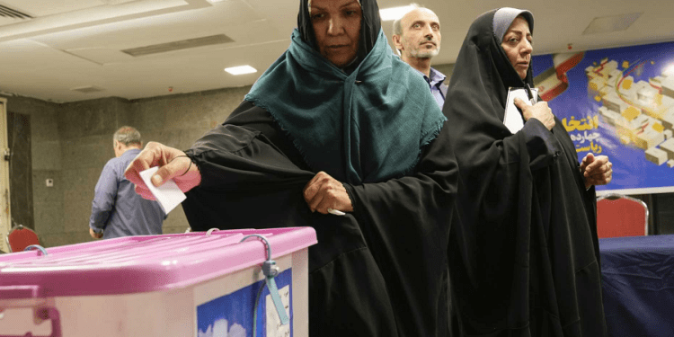 Iranian citizens cast their votes during the presidential election at a polling station inside the Iranian embassy in Baghdad, Iraq, Friday, June 28, 2024.