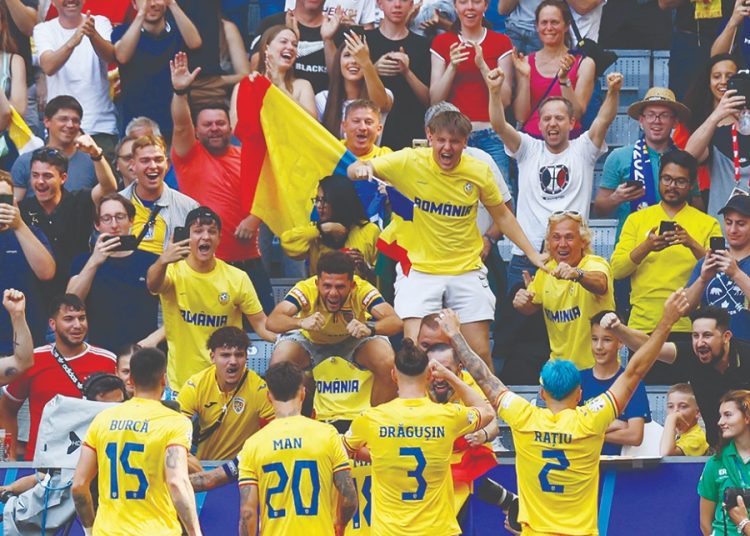 Romania's players celebrate with fans scoring their second goal against Ukraine at the Euro 2024 Group E opener.