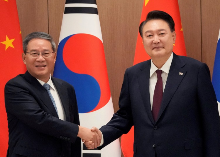 South Korean President Yoon Suk Yeol (R) shakes hands with Chinese Premier Li Qiang during a meeting in Seoul on May 26, 2024.