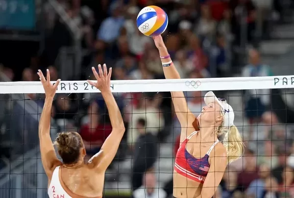 United States' Taryn Kloth (R) reaches the ball before Canada's player during the women's beach volleyball match.