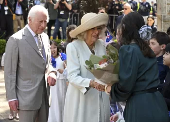 Children greet King Charles III and Queen Camilla outside a Sydney church