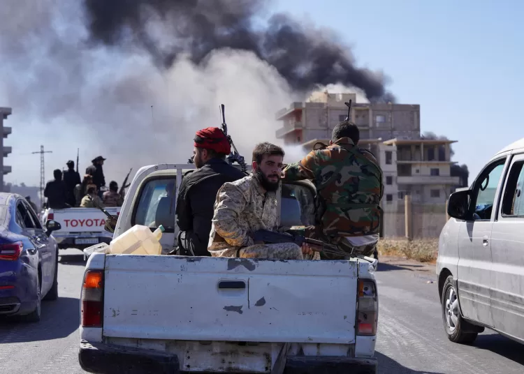 Smoke rises while Syrian security forces sit in the back of a truck as Syrian troops entered Sweida on Tuesday following two days of clashes, in Sweida, Syria July 15, 2025.