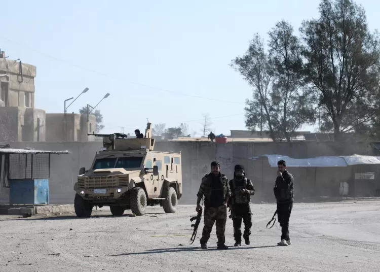Syrian Democratic Forces (SDF) fighters walk near an armored vehicle, following clashes between SDF and Syrian government forces, in Hasakah, Syria, January 20, 2026.