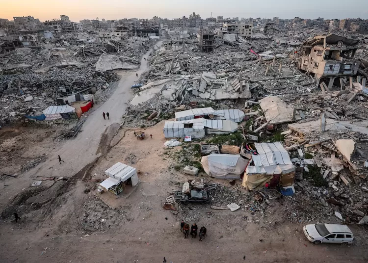 Palestinians gather near the rubble of residential buildings destroyed during the two-year Israeli offensive, on the first day of the holy month of Ramadan, in Gaza City, February 18, 2026. REUTERS/