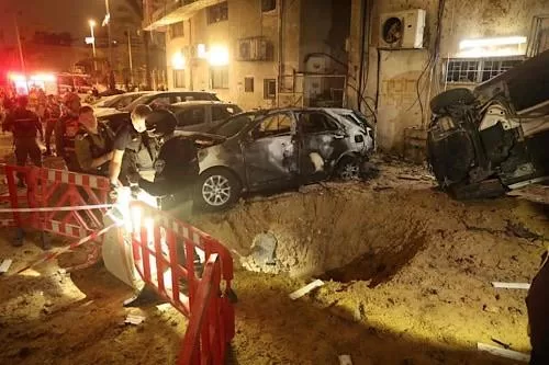 Israel approves emergency defence funding amid Iran conflict 1 - Egyptian Gazette Israeli security forces check the damage to cars after a rocket strike in Holon, in the Tel Aviv District on March 15, 2026. (AFP)