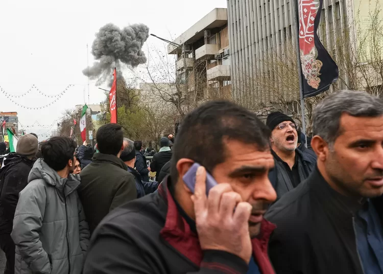 Blast hits Tehran after Israel threat to target rally area 1 - Egyptian Gazette Smoke from an explosion rises behind demonstrators attending the annual anti-Israeli Quds Day, or Jerusalem Day, rally in support of Palestinians in Tehran, Iran, Friday, March 13, 2026.