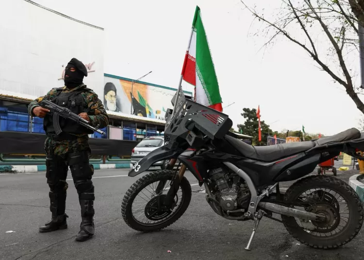 A member of a police force stands guard on a street, amid the U.S.-Israeli conflict with Iran, in Tehran, Iran, March 23, 2026.