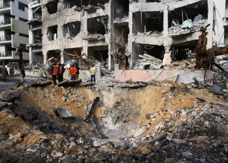 Rescue workers and military personnel survey the scene of a direct hit a day after an Iranian missile struck in Tel Aviv, Israel, Sunday, March 1, 2026.