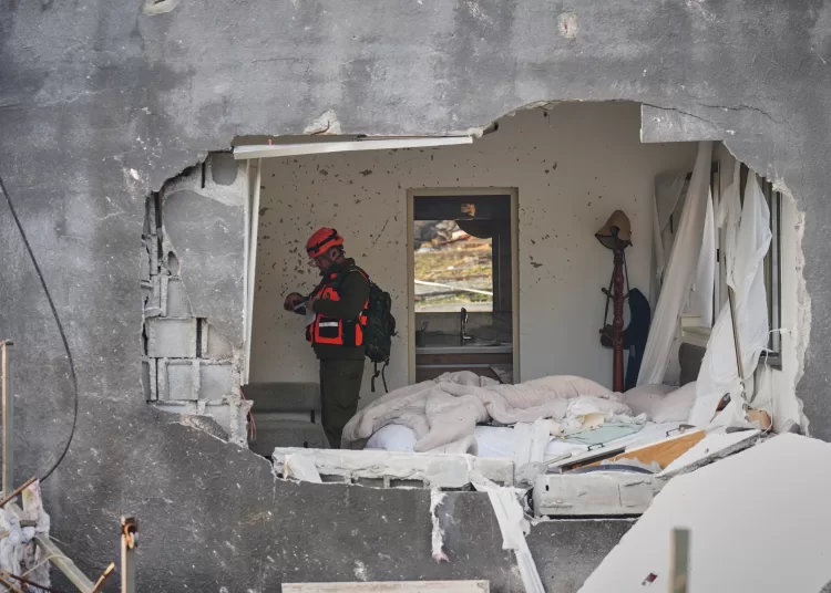 Trump threatens Iran following new wave of attacks on Gulf states, Israel 12 - Egyptian Gazette An officer from Israel’s Home Front Command inspects a house destroyed by an Iranian missile strike in Zarzir, northern Israel, Friday, March 13, 2026.
