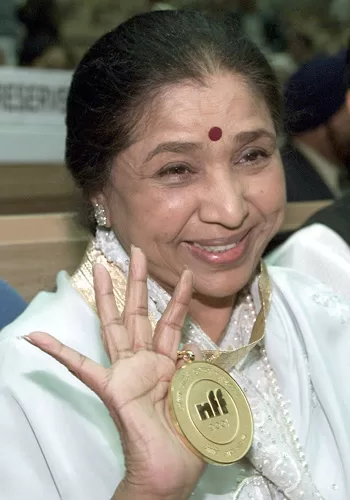Indian singer Asha Bhosle dies 12 - Egyptian Gazette Singer Asha Bhosle holds aloft a Dada Saheb Phalke award, a lifetime achievement during the 48th National Film Awards in New Delhi, December 12, 2001. REUTERS