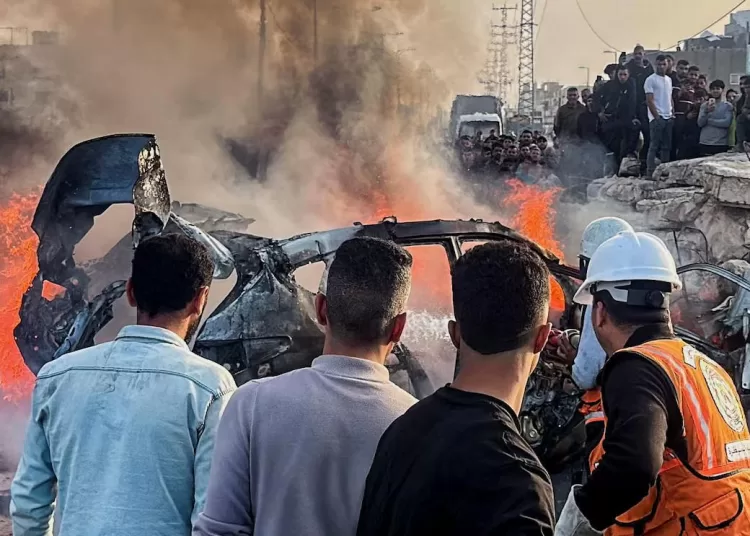 Palestinians inspect the site of what medics said was an Israeli airstrike on a car near the entrance to Zawayda town, amid the U.S.-Israeli conflict with Iran, in the central Gaza Strip, April 4, 2026.