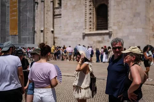 Italy on alert as France, Portugal hit record May heat 10 - Egyptian Gazette A woman shades her head with a fan in front of Jeronimos Monastery in Belem, during a heatwave in Lisbon on May 27, 2026. (AFP)
