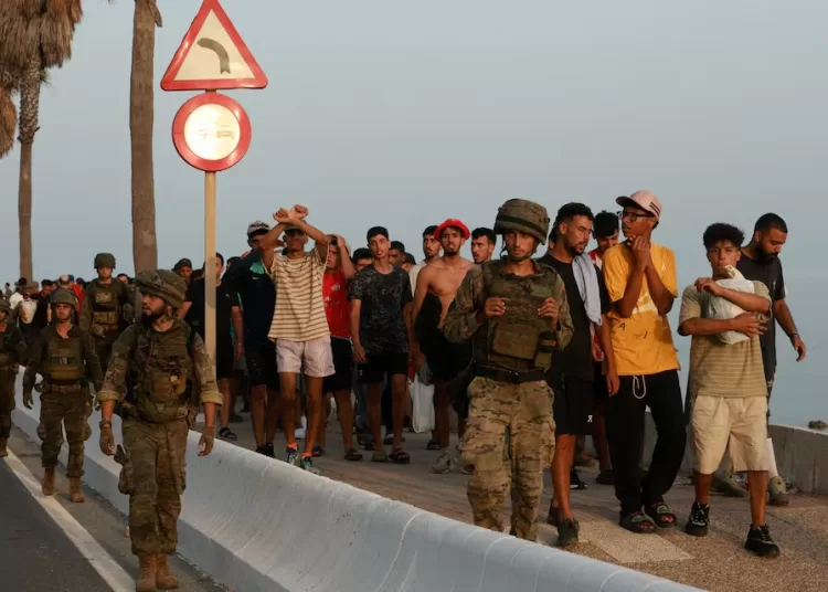 Members of the military escort migrants in Ceuta, Spain, following recent mass crossings of migrants on foot and by sea from Morocco into Spanish territory, August 1, 2026. REUTERS