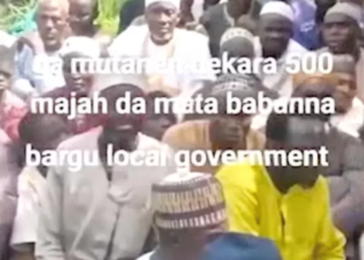 People sit on the grass in this screen grab obtained from a social media video released by an armed group on August 23, 2026, showing what residets said were about 600 women, children and older people abducted in an attack on a mosque in Nigeria’s north-central Niger State.