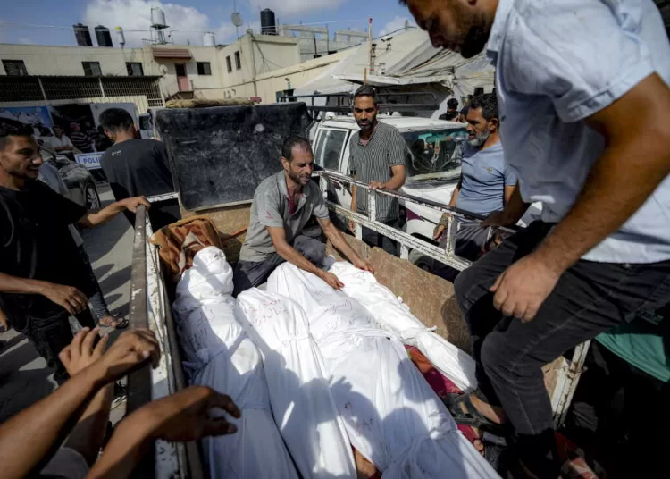 Palestinians gather near the bodies of their relatives killed in the Israeli bombardment of the Gaza Strip, at a hospital morgue in Deir al-Balah, Saturday, July 13, 2024. (AP Photo/Abdel Kareem Hana)