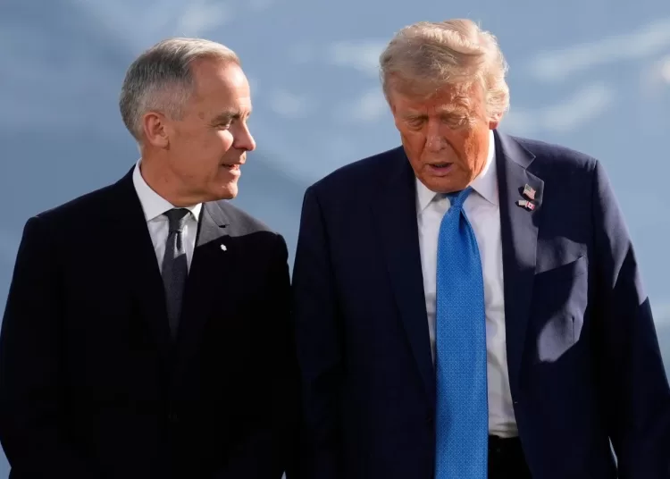 Canada’s Prime Minister Mark Carney talks with President Donald Trump before a group photo at the G7 Summit, June 16, 2025, in Kananaskis, Canada.