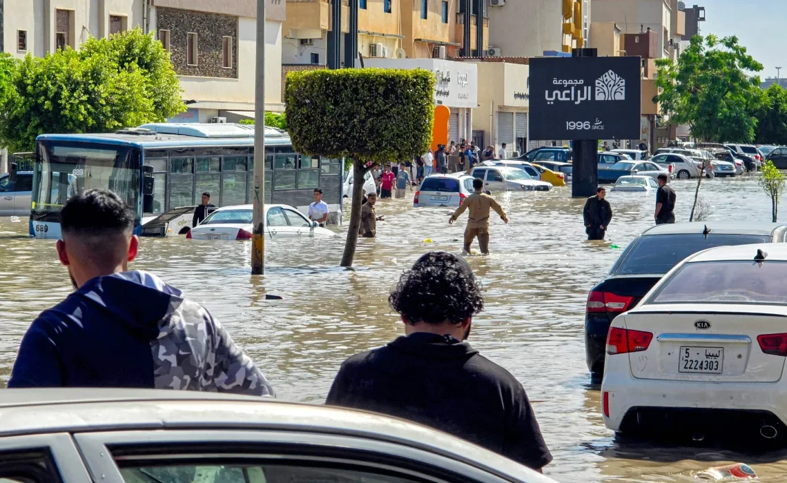 Heavy rains flood Libya’s capital, cause damage 11 - Egyptian Gazette People walk near stalled vehicles along a flooded street following heavy rains in Libya's capital Tripoli on October 13, 2026. (AFP)