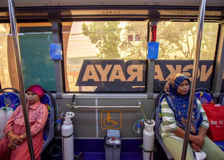 Residents receive oxygen from a free mobile oxygen bus deployed by the city government amid haze from wildfires in Palangka Raya, Central Kalimantan province, Indonesia, October 23, 2026. REUTERS/