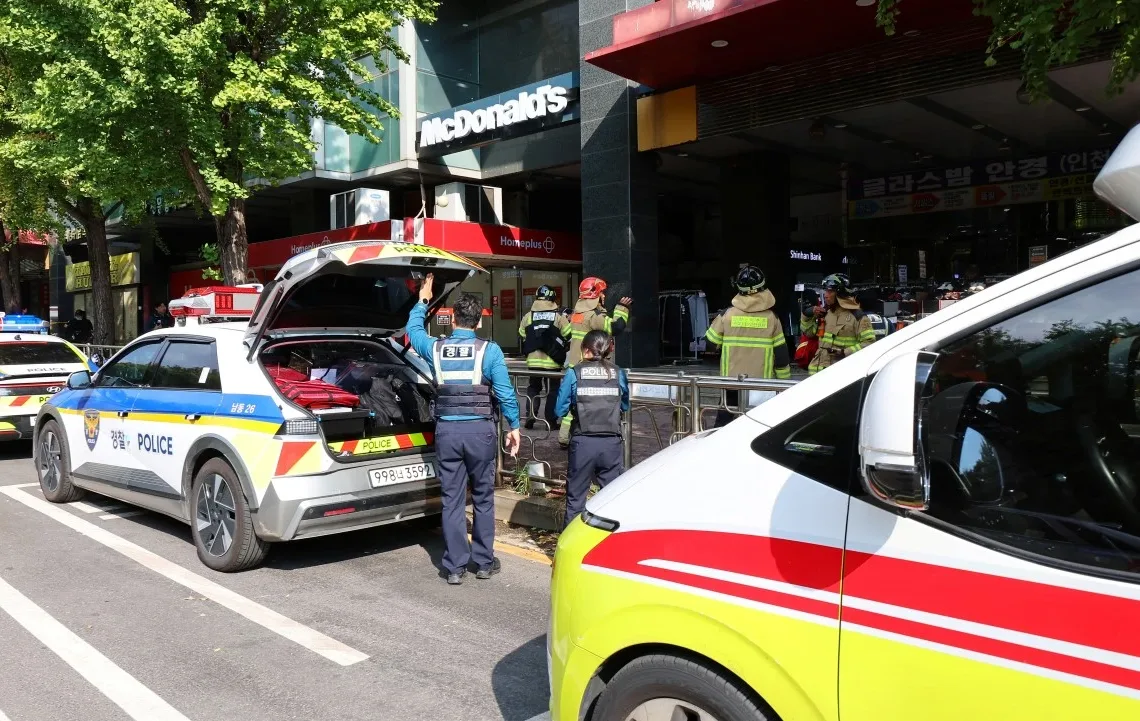 Police officers and firefighters arrive at the scene after a stabbing incident at a supermarket in Incheon. (AFP)